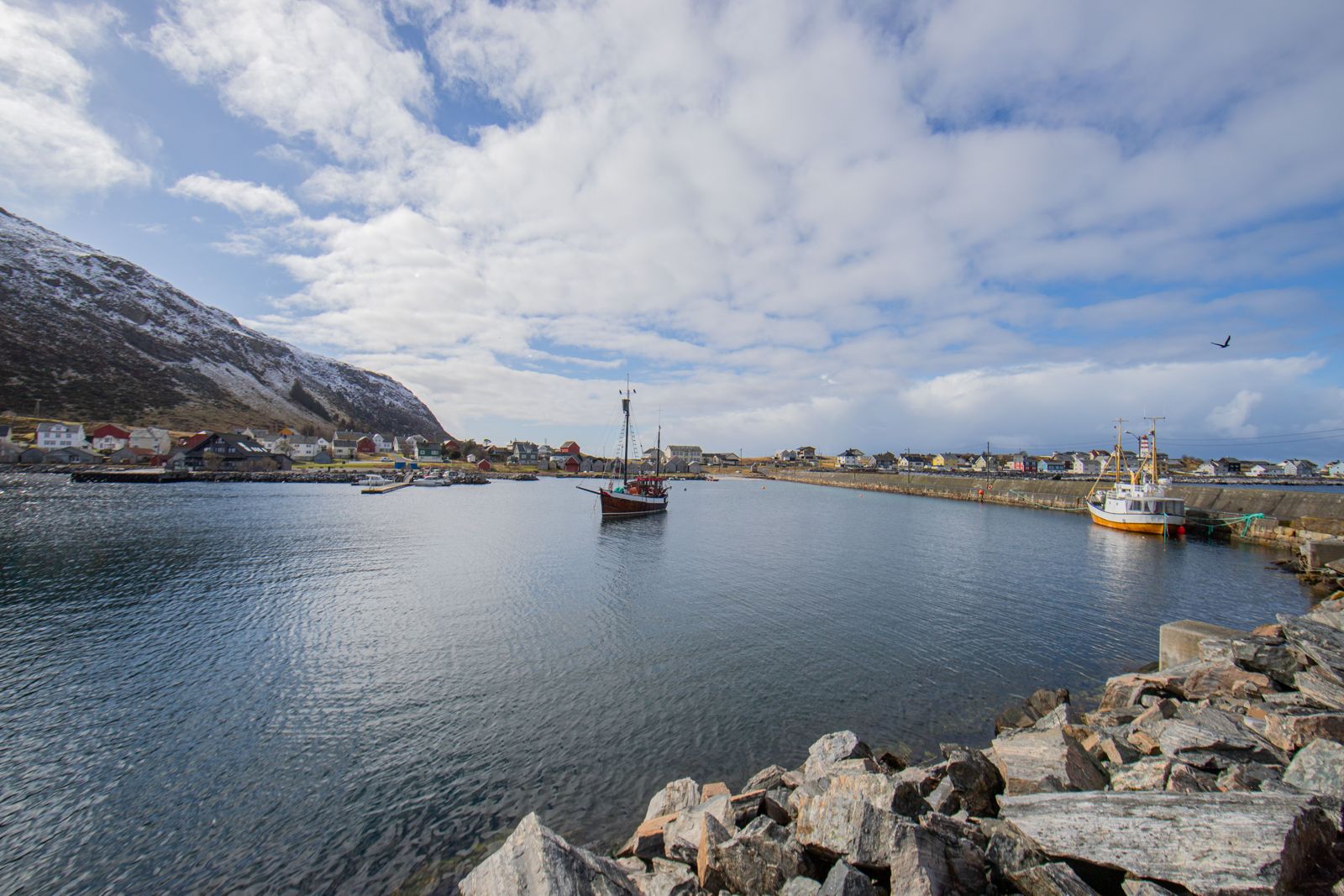 Hafenszene mit Fischerbooten vor Bergkulisse in einem norwegischen Küstenort