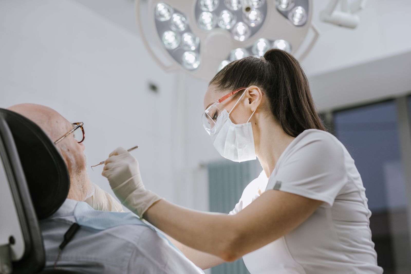 Fachzahnärztin behandelt konzentriert einen Patienten in der Praxis